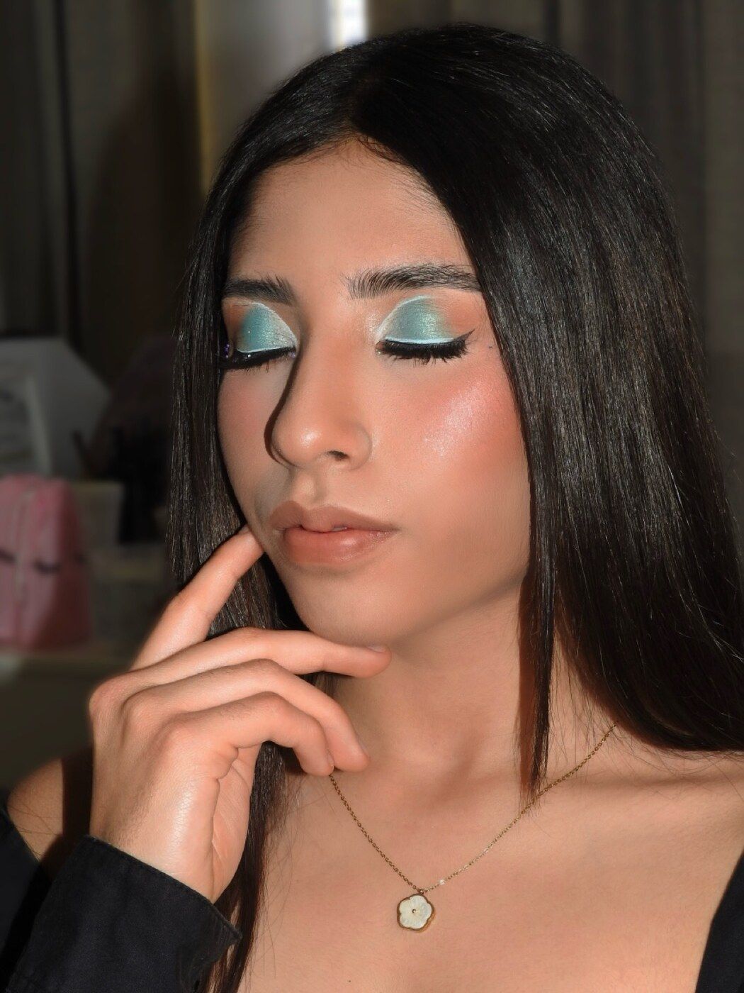 Maquillaje editorial con sombra turquesa metálica y labios nude