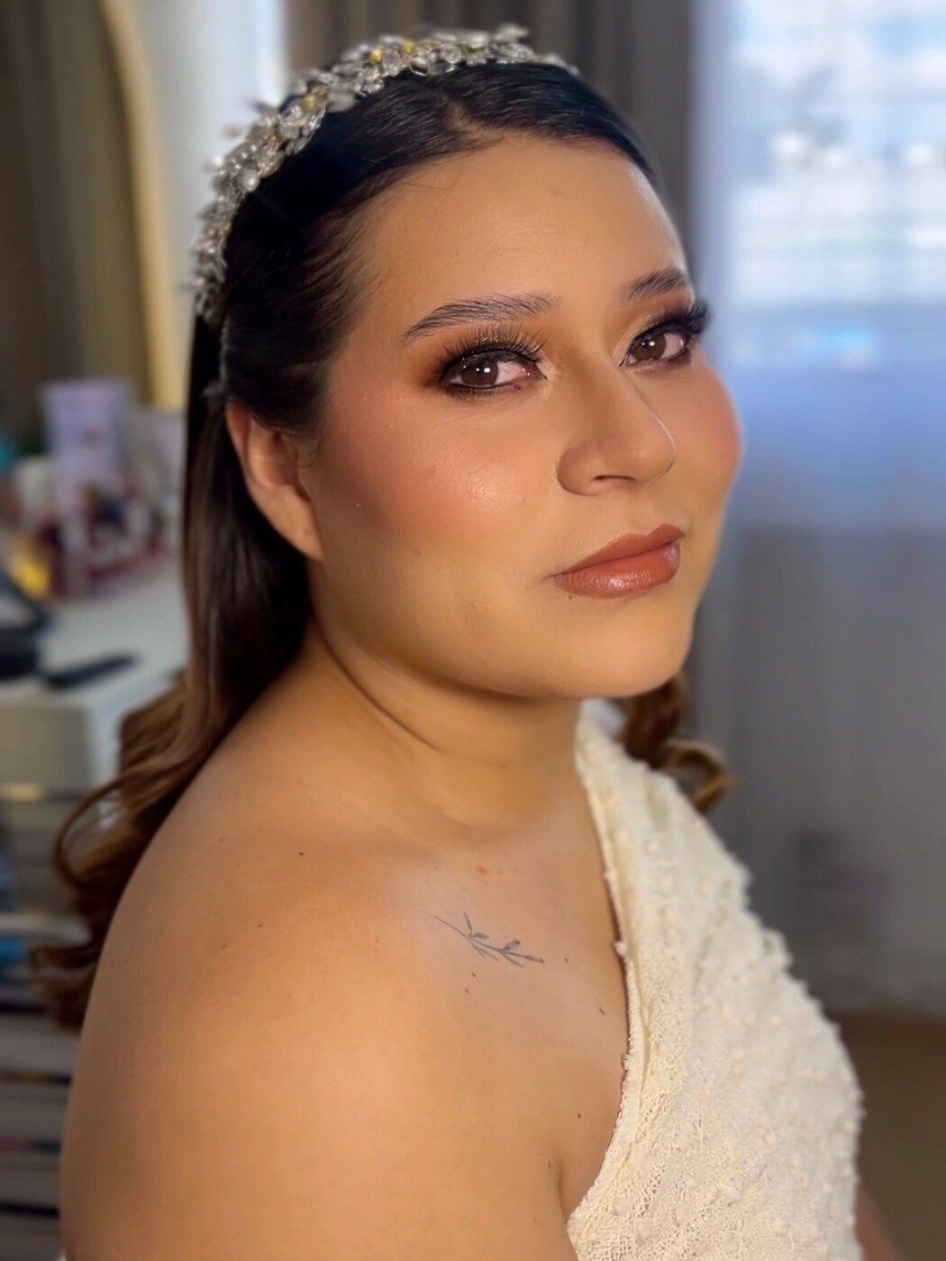 Novia con tiara de cristales y maquillaje luminoso en tonos cálidos