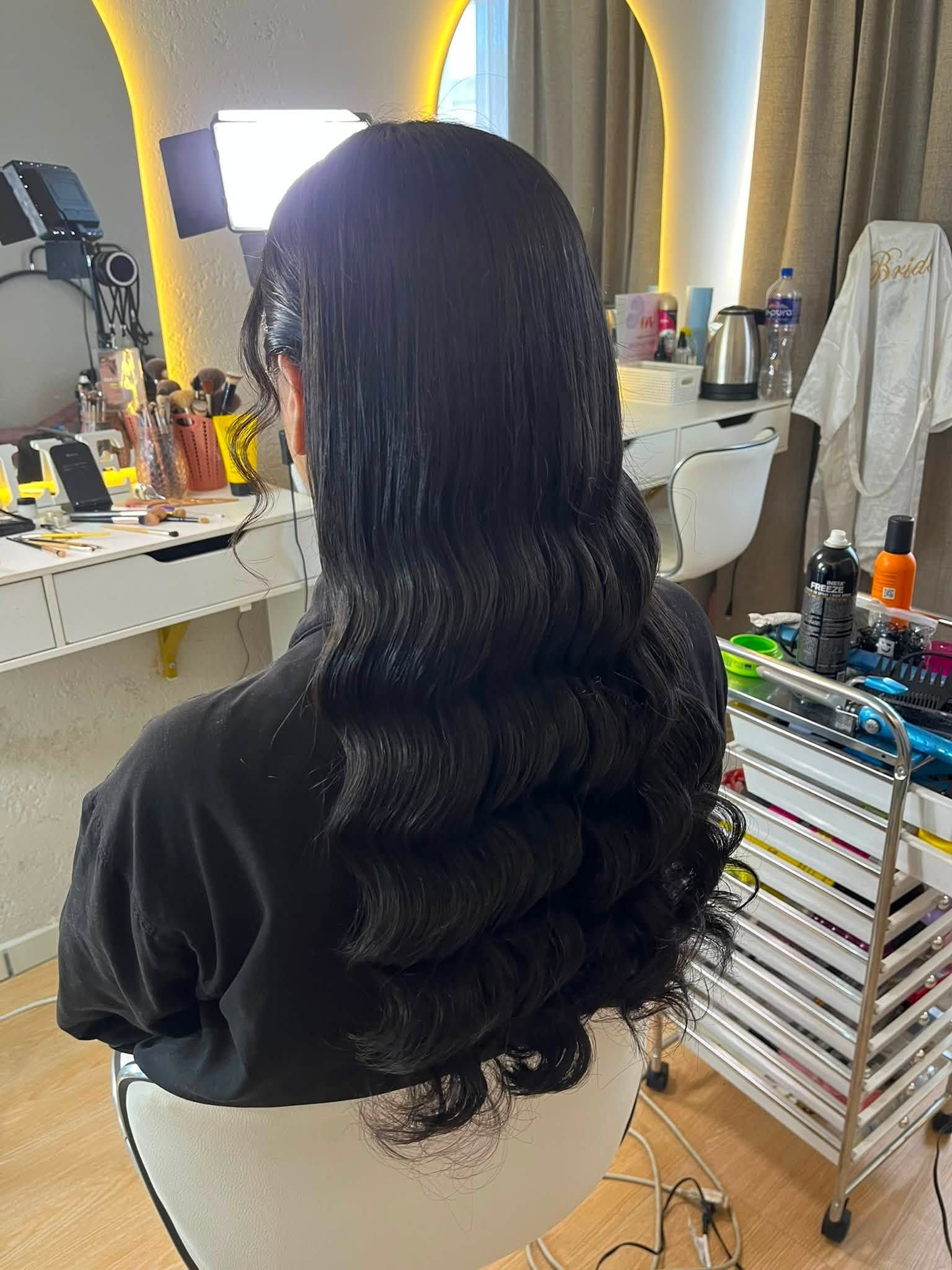 Peinado de cabello negro con ondas largas y volumen visto desde atrás