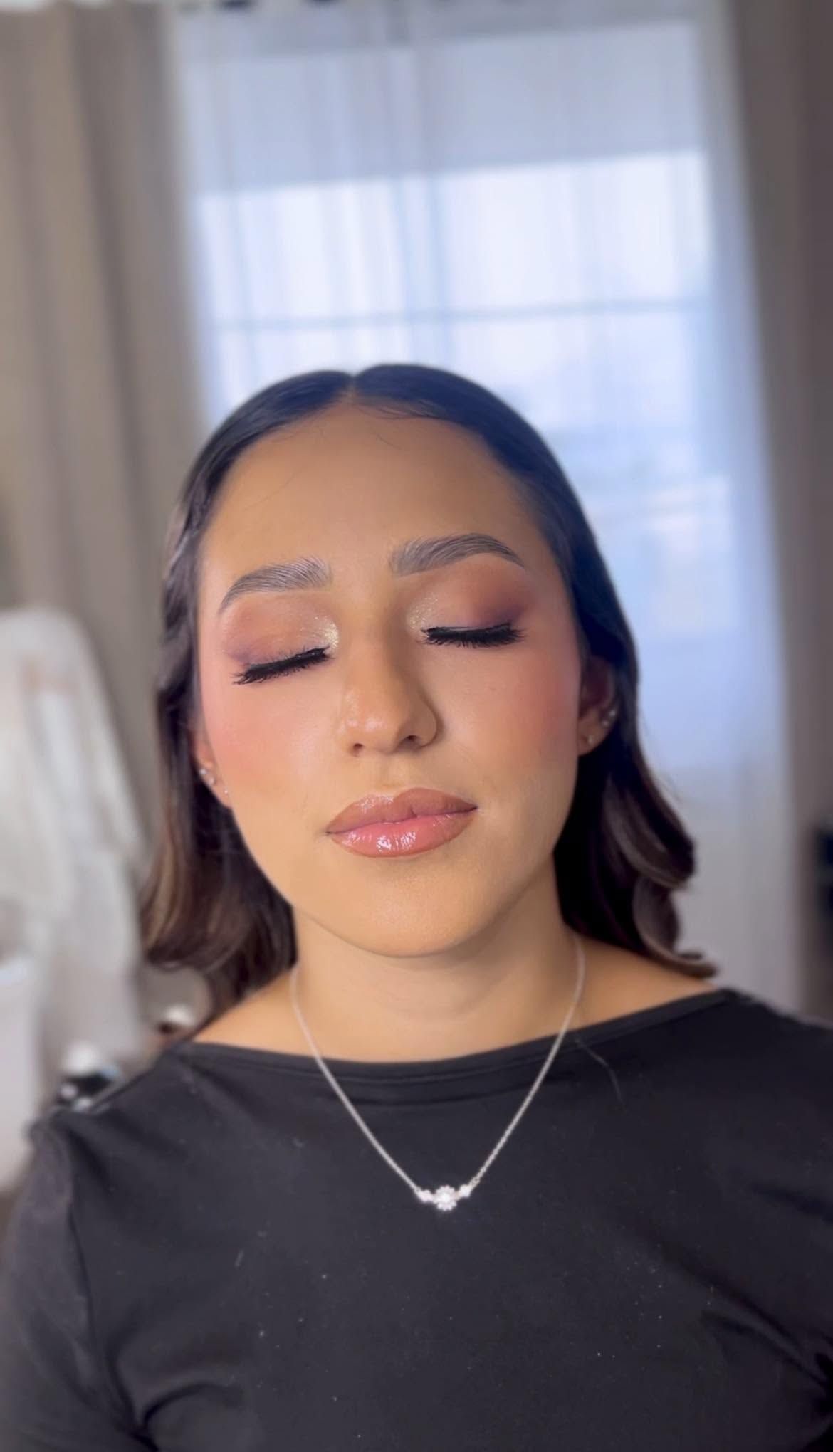 Maquillaje social de ojos luminosos, labios rosados y cabello oscuro recogido