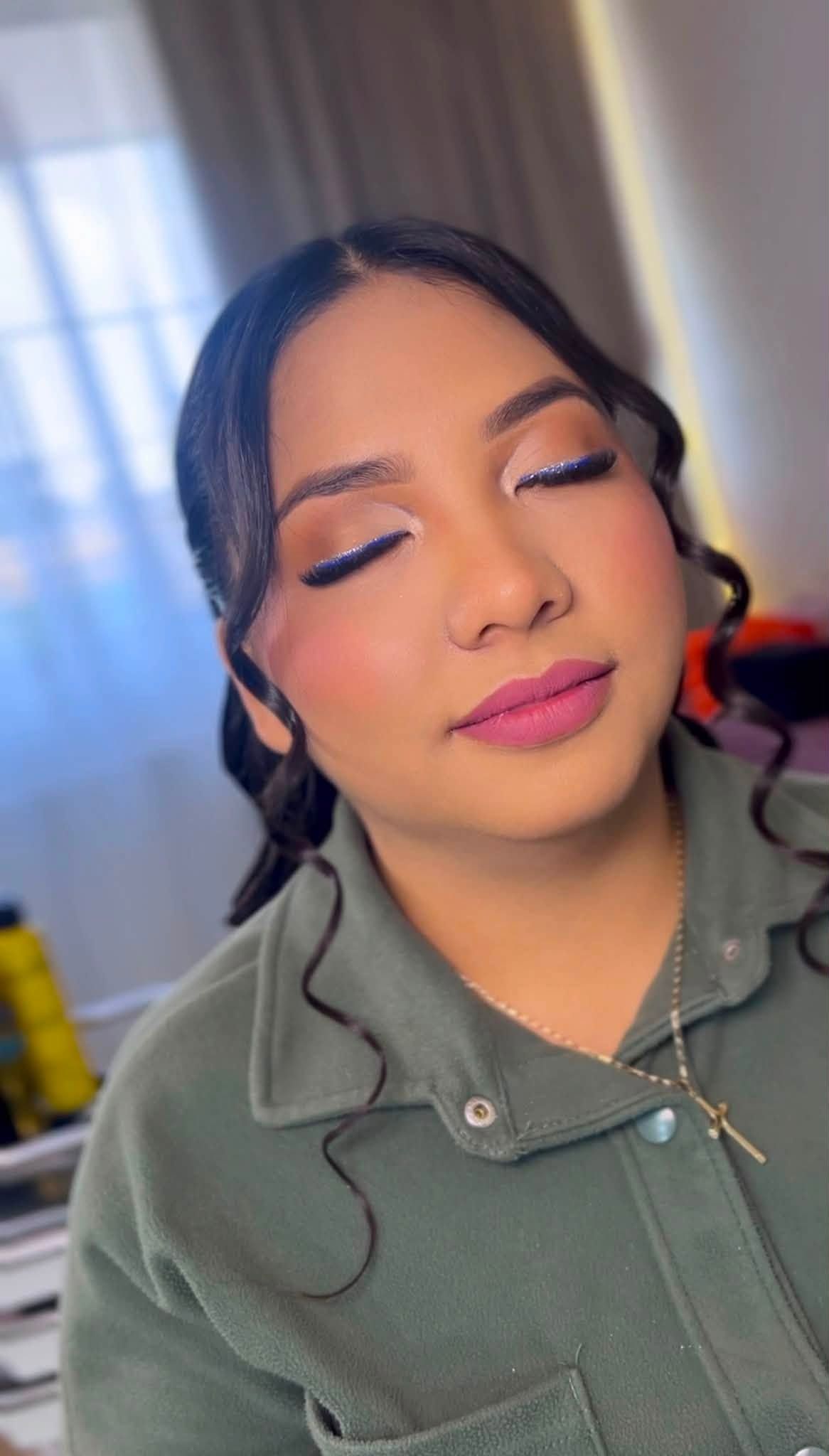 Maquillaje con delineado azul brillante y labios rosa