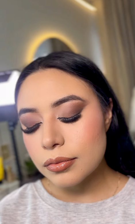 Primer plano con ojos cerrados que muestra sombras ahumadas malva y labios brillantes