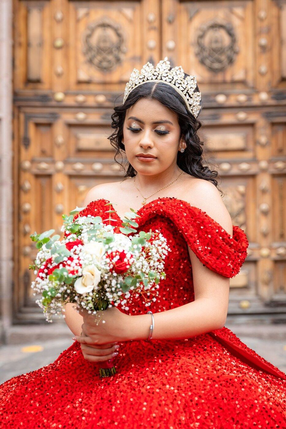Quinceañera con vestido rojo y corona, maquillaje de Michelle Corona Studio