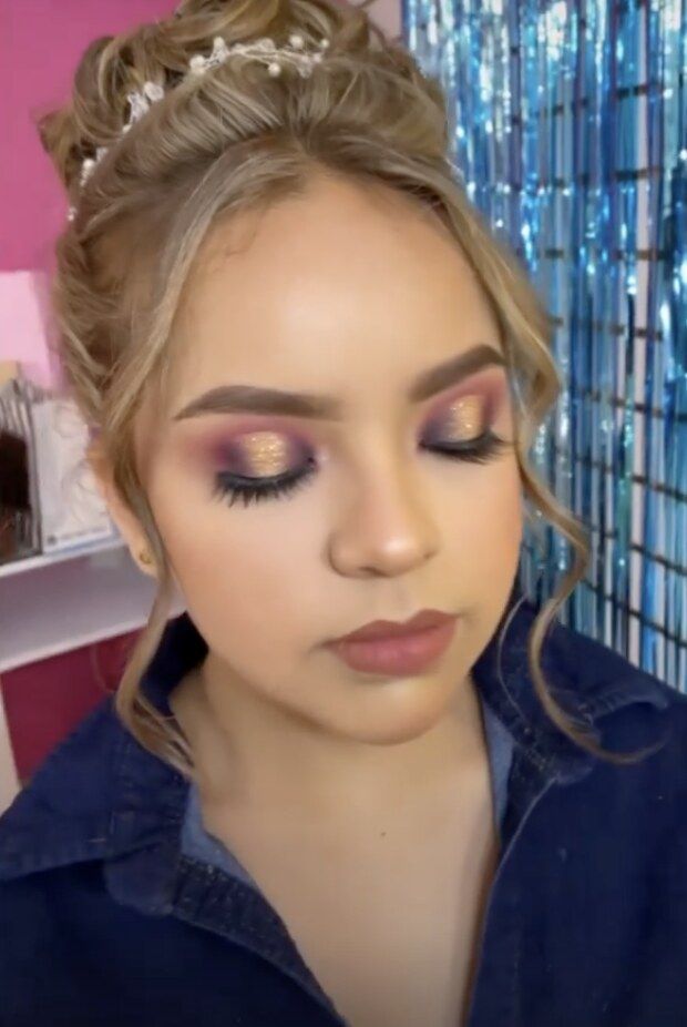Quinceañera con corona y sombras en tonos morados y dorados